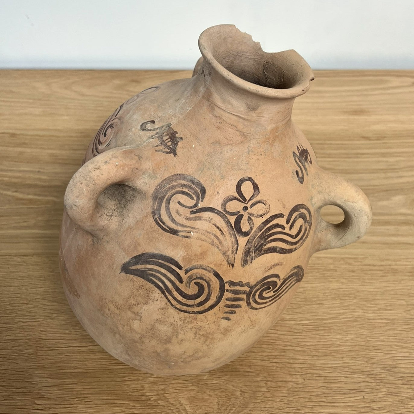 Ceramic jar with decorative patterns on a wooden surface