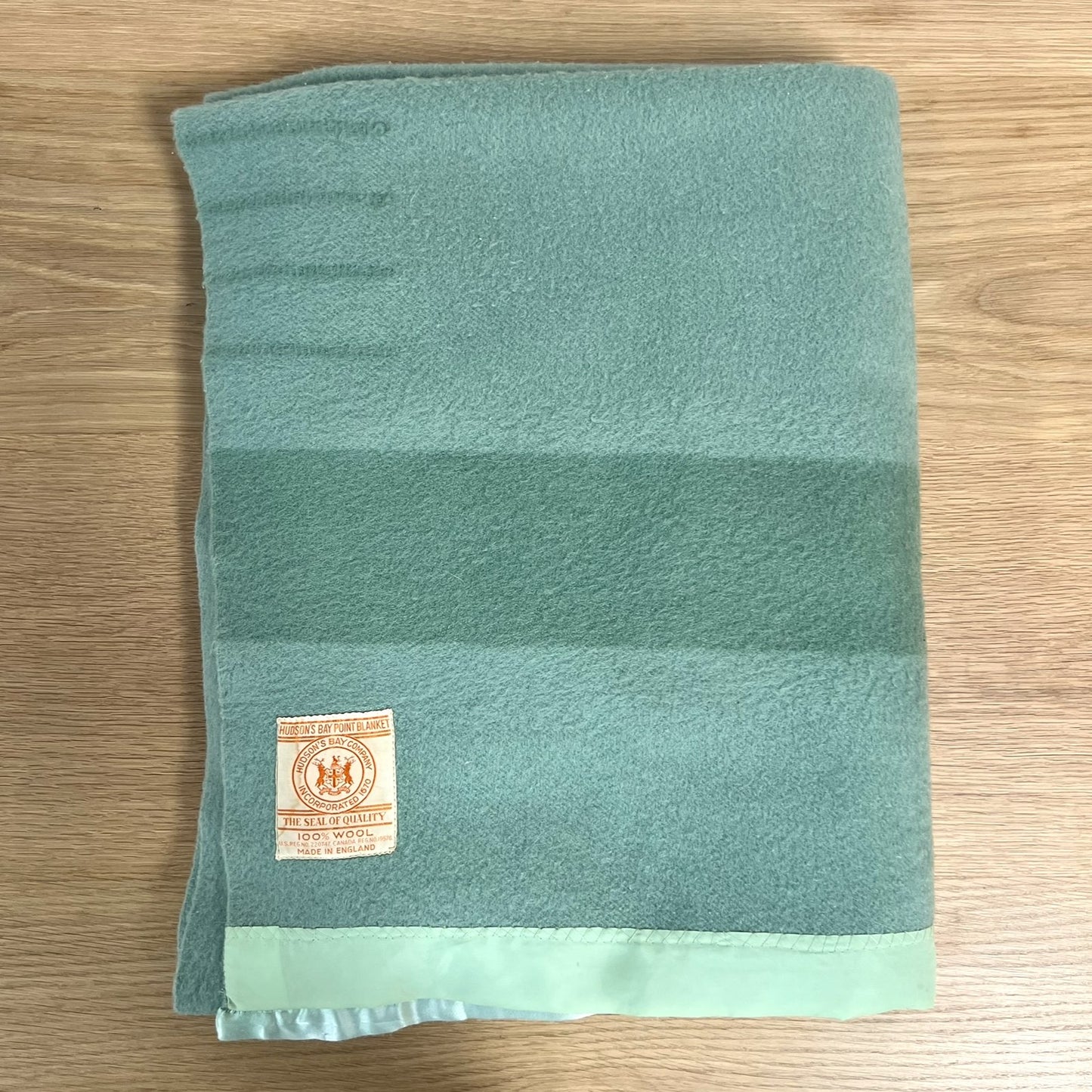 Hudson's Bay Point Blanket label with branding and text on a textured teal wool blanket