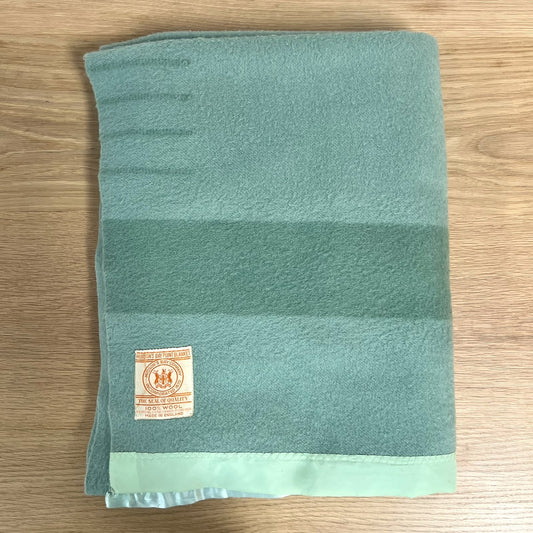 Hudson's Bay Point Blanket label with branding and text on a textured teal wool blanket