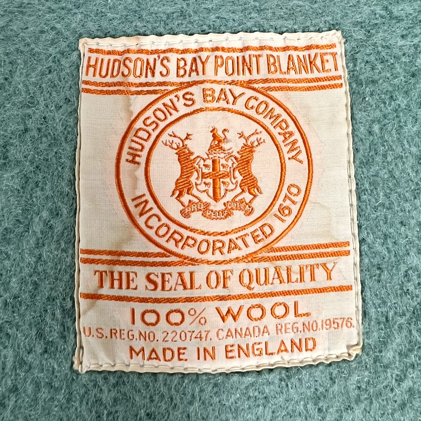 Hudson's Bay Point Blanket label with branding and text on a textured teal wool blanket