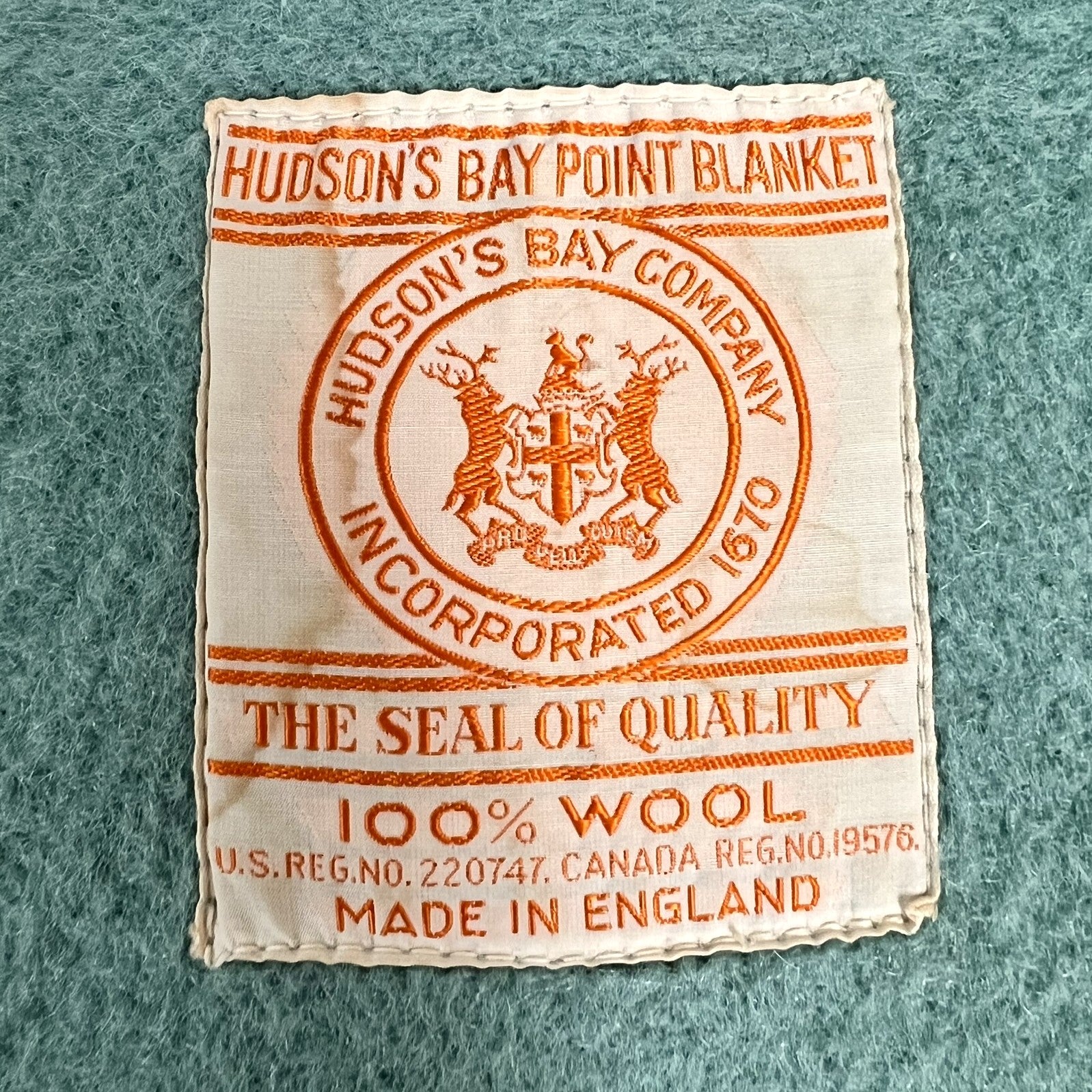 Hudson's Bay Point Blanket label with branding and text on a textured teal wool blanket