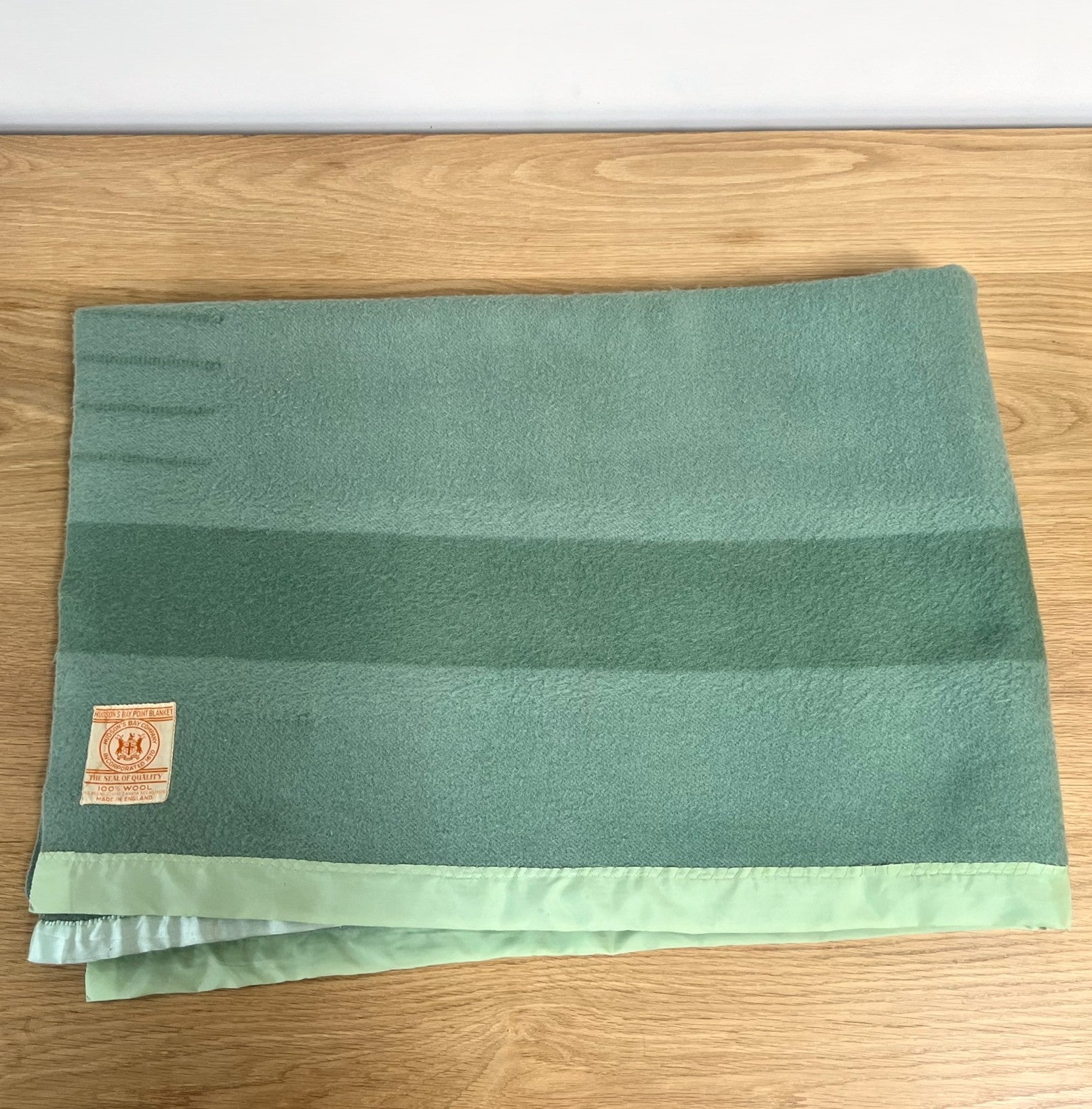 Hudson's Bay Point Blanket label with branding and text on a textured green wool blanket