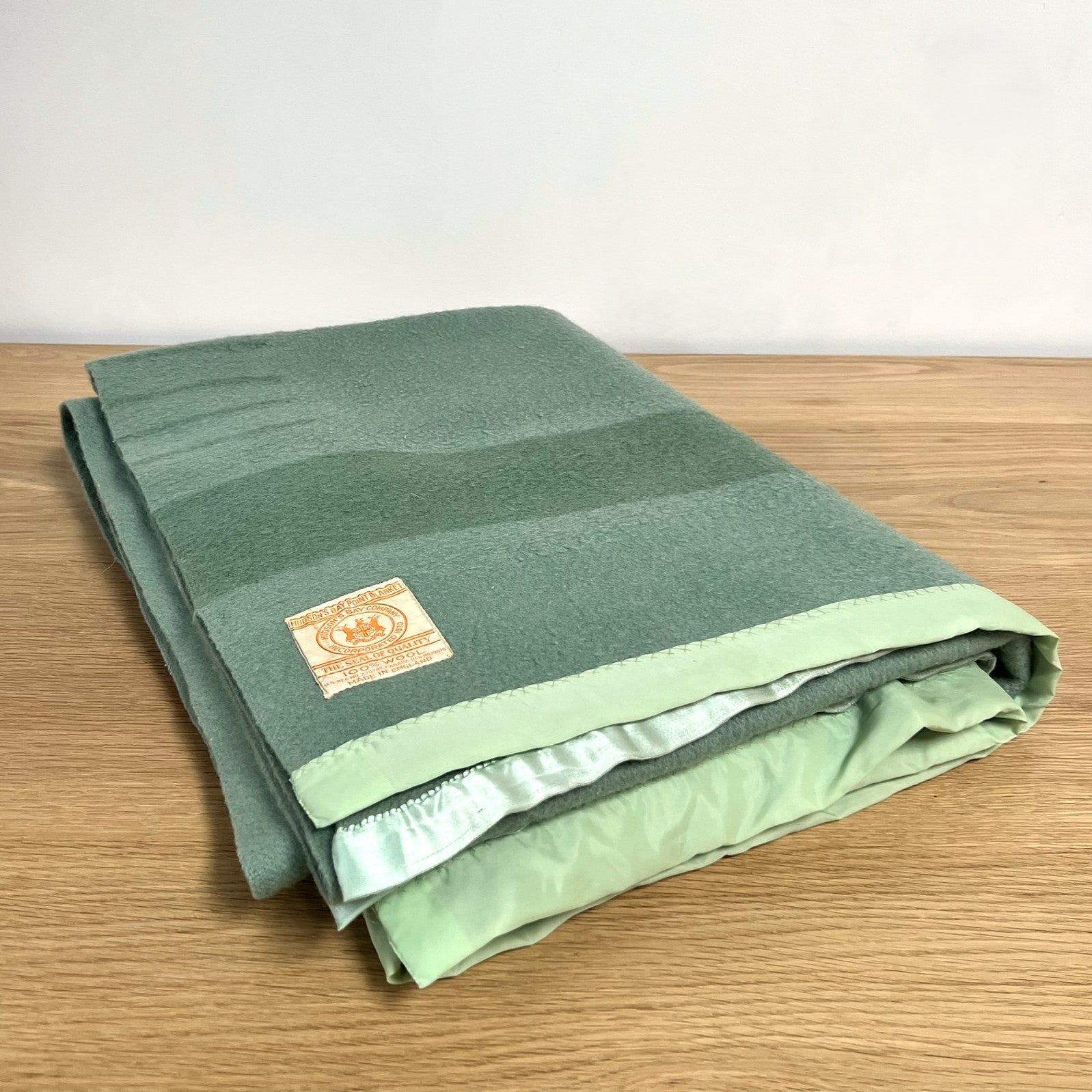 Hudson's Bay Point Blanket label with branding and text on a textured green wool blanket